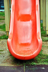 Red plastic slide detail at a kids playground.