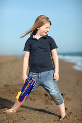 Happy girl with toy gun on the beach