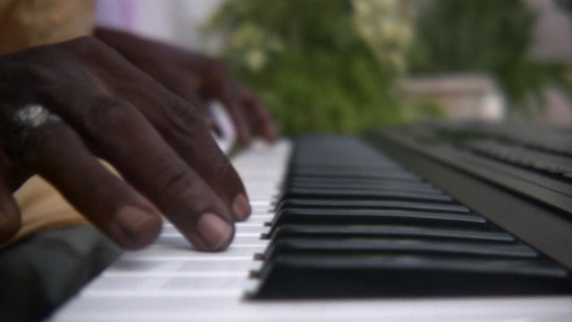 Black man playing the keyboard piano