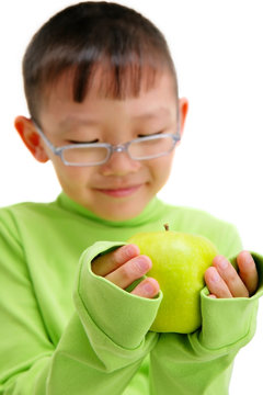 young asian boy with a big green apple