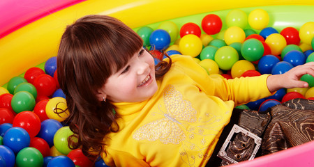 Fototapeta na wymiar Preschooler girl with ball in play room.