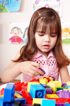 Child with  block and construction set in play room.