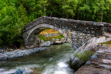 Fototapeta na wymiar Ponte romano antico su torrente di alta montagna