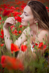 Naklejka premium girl sitting in a field of poppies