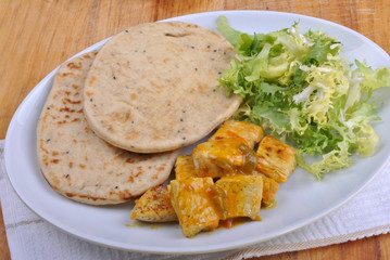 naan bread with turkey curry on a plate