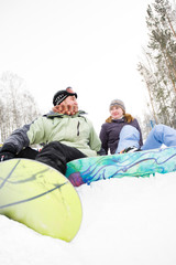 pair of snowboard sitting beside him on the snow