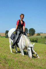 Frau reitet Pferd