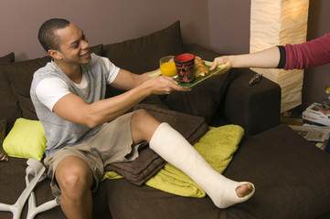 Homme jambe cassé prends son petit déjeuner