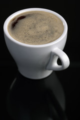 Cup of espresso coffee over black background.