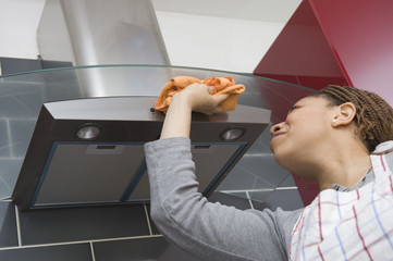 Femme Lavant la hotte de la cuisinère