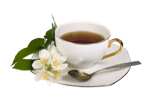 White cup of tea with jasmine flowers isolated on white