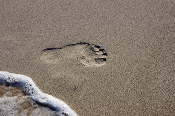 imprint of human feet in the sand