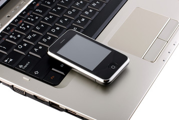 mobile phone with touchscreen on gray laptop