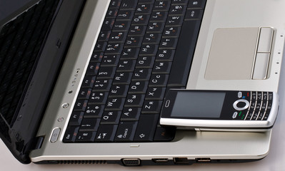 mobile phone with buttons on gray laptop