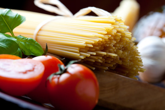 Raw pasta with tomato, basill and garlic close up