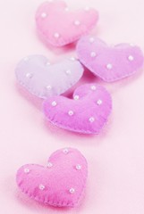 Five cloth hearts on a fiber textured background