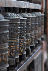 Obraz na płótnie Canvas buddhist prayer wheels in a row