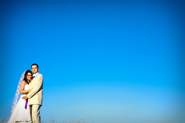 wedding couple against blue sky in the evening copy space