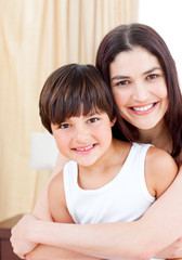 Smiling mother hugging her son