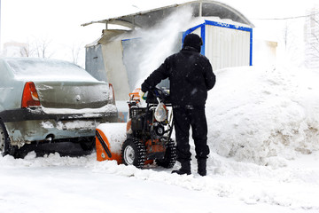 Snowblower in city under snowfall