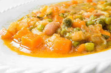 Vegetable soup on white dish.