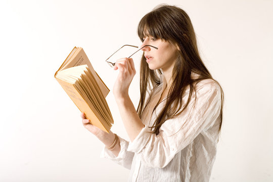 jeune femme lit en faisant loupe avec ses lunettes