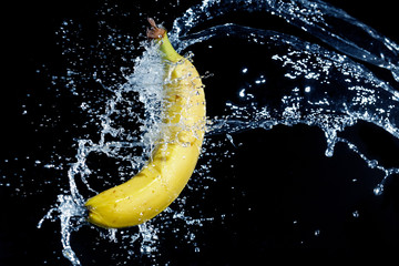 fresh banana gets hit by a water stream - Powered by Adobe