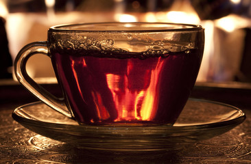 cup of tea the backdrop of fire in the fireplace
