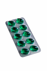 Green tablets in silver package isolated over white background.