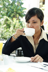 An Asian business executive drinking coffee