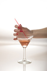 Beautiful hand with perfect red manicure holding martini glass