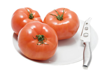 red tomatoes on white plate with knife