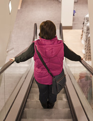 Frau auf der Rolltreppe im Kaufhaus