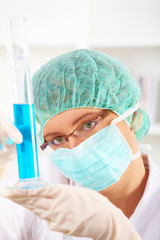 Closeup of a female researcher holding up a test tube