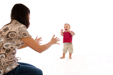 Mother encouraging baby to take first walking steps