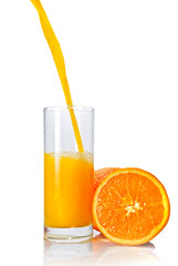 orange juice poring into glass isolated on white