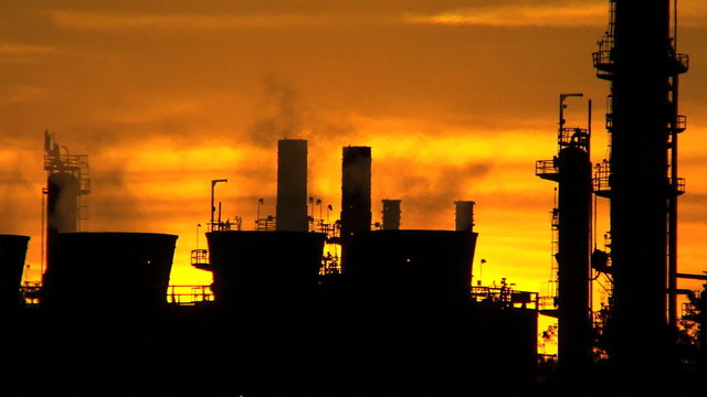 Sunset silhouette of Oil Refinery Chimneys