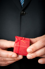 Businessman holding a small red gift box