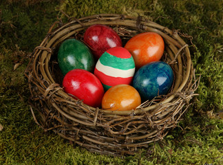 Ein Osternest gefüllt mit schön bunt bemalten Eiern