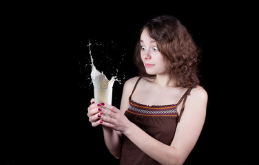 Female holding glass with splashing milk