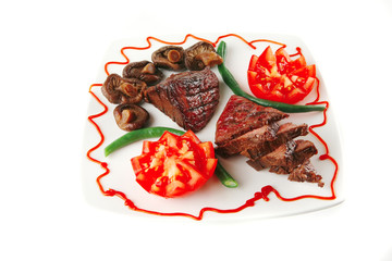 roast veal fillet on a plate with tomatoes