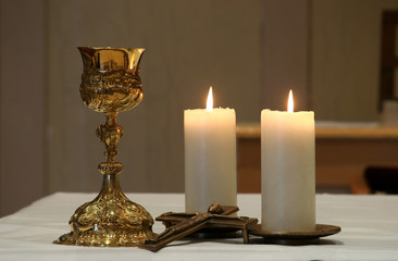 Golden chalice and two burning candles