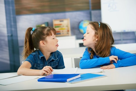 Children sticking tongue in classroom