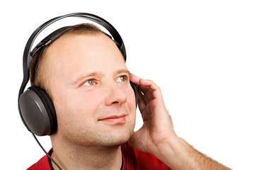 Young man listening to the music in headphones isolated on white