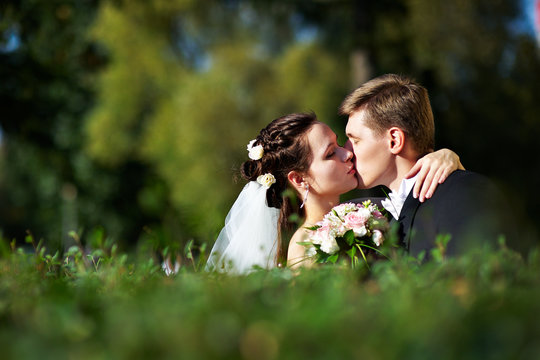 Romantic kiss the bride and groom at wedding walk