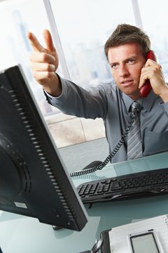 Businessman calling and gesturing in office