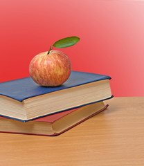 Red apple and books on desk