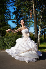 Happy bride wedding dancing in park