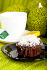 Muffin with coconut decoration and a cup of tea