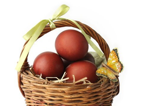 Red dyed eggs and a butterfly in a basket